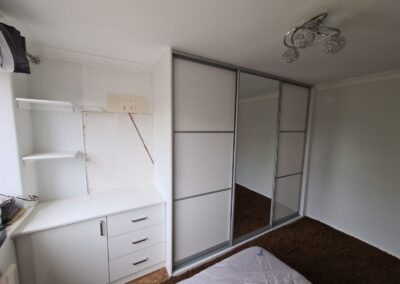desktop with cupboard and drawers next to fitted wardrobe